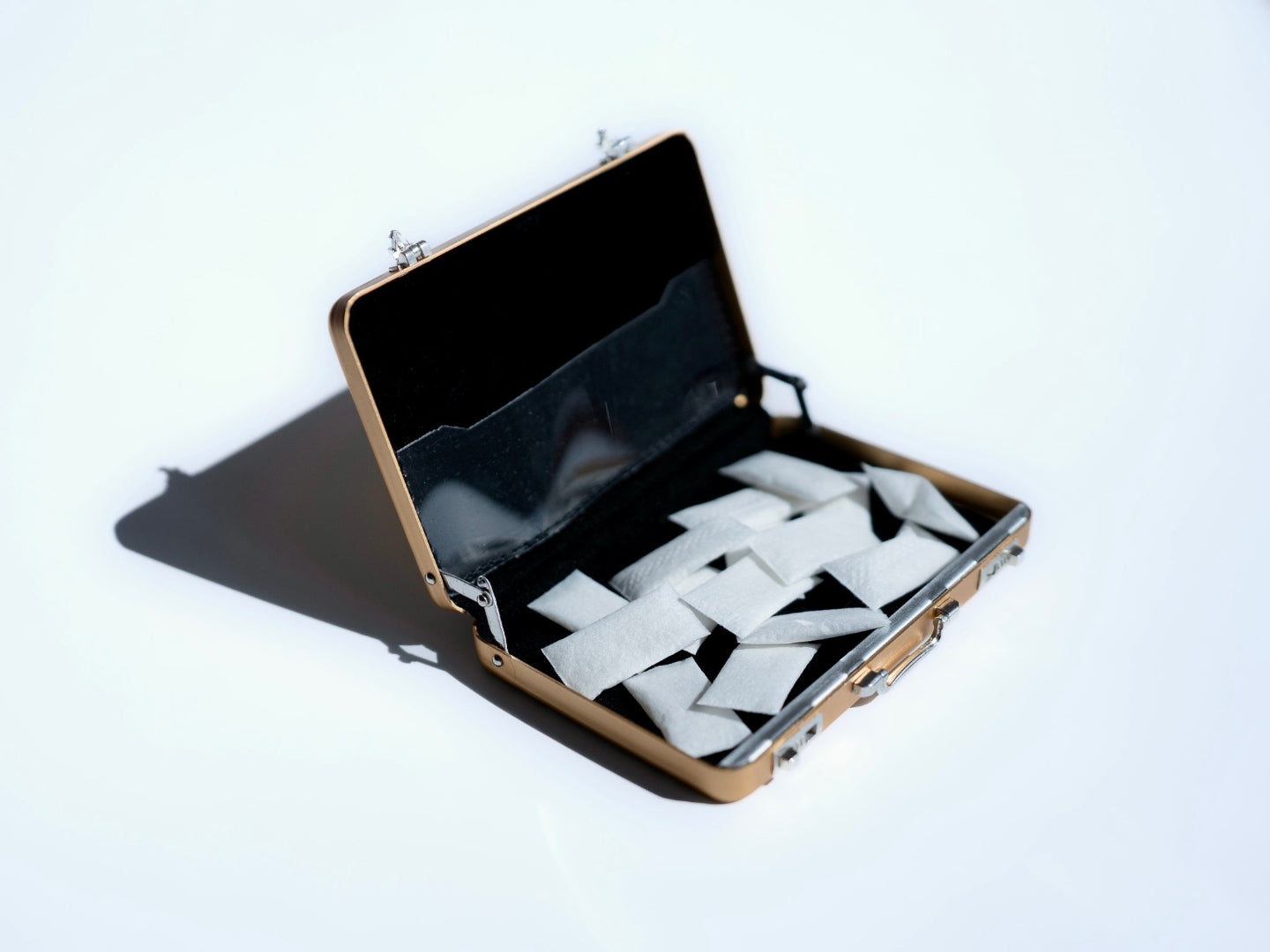 Gold Tiny Suitcase open with nicotine pouches inside
